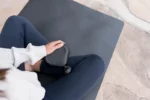Mujer utilizando aparato de masaje Theragun Mini
