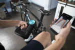 Ciclista utilizando en la pierna Theragun PRO con la aplicación del celular